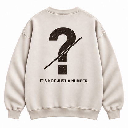 Close-up of customizable question mark graphic on the back of a cream oversized crewneck sweatshirt